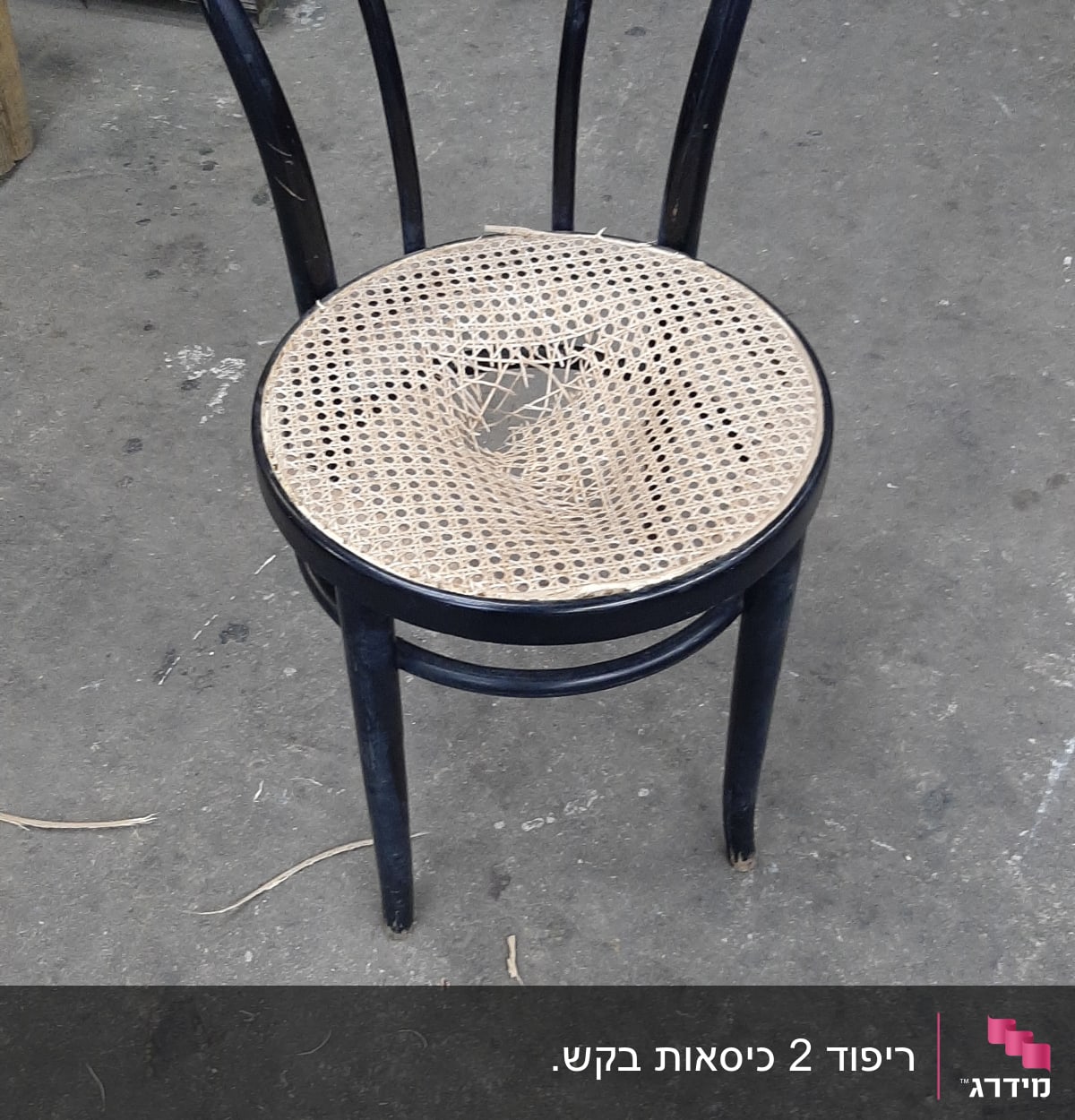 כיסא עם מושב קש קרוע על רצפת בטון